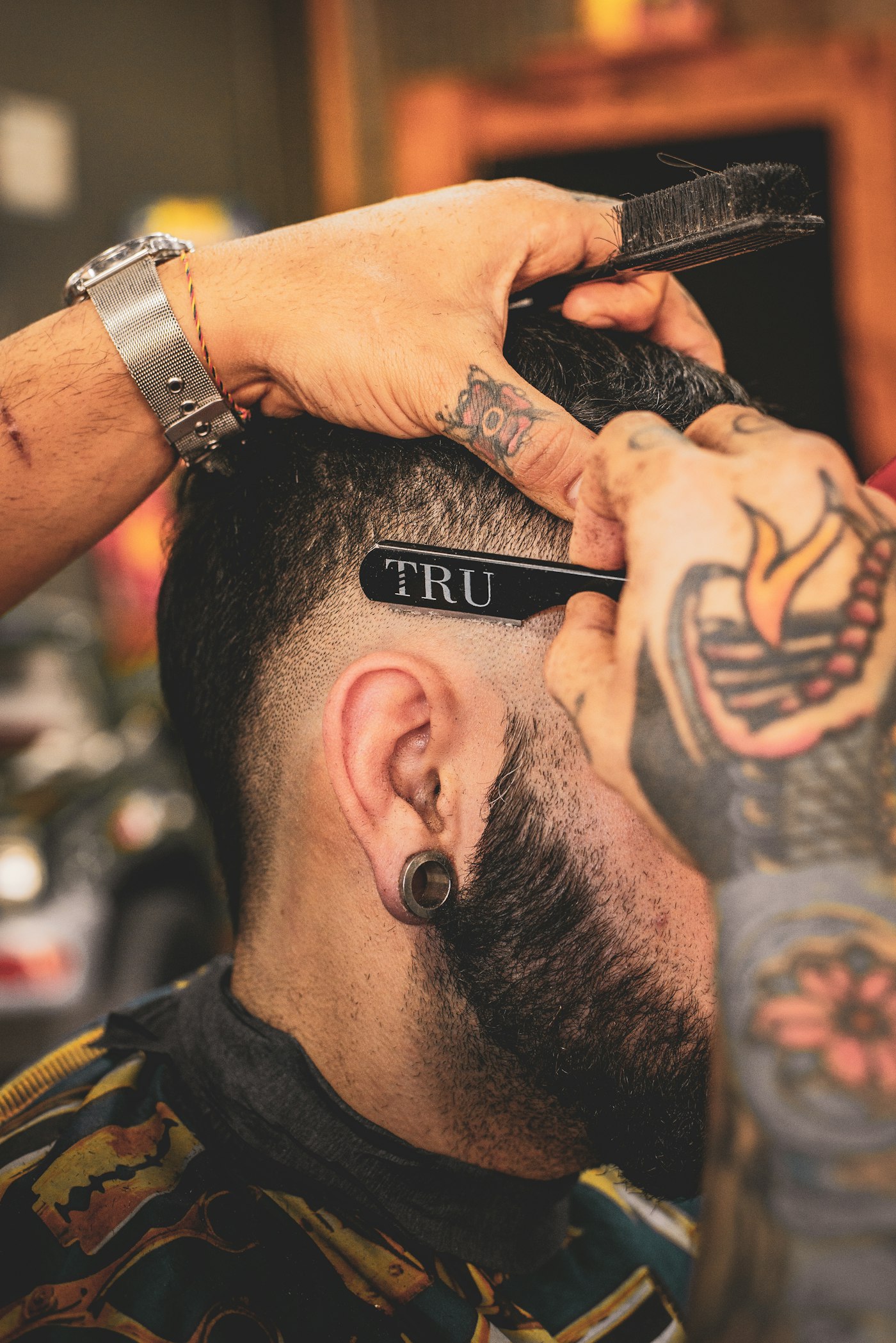 Illustrative close-up of a barber shaping a man’s hair with a razor; not Fade Check staff, customers or results