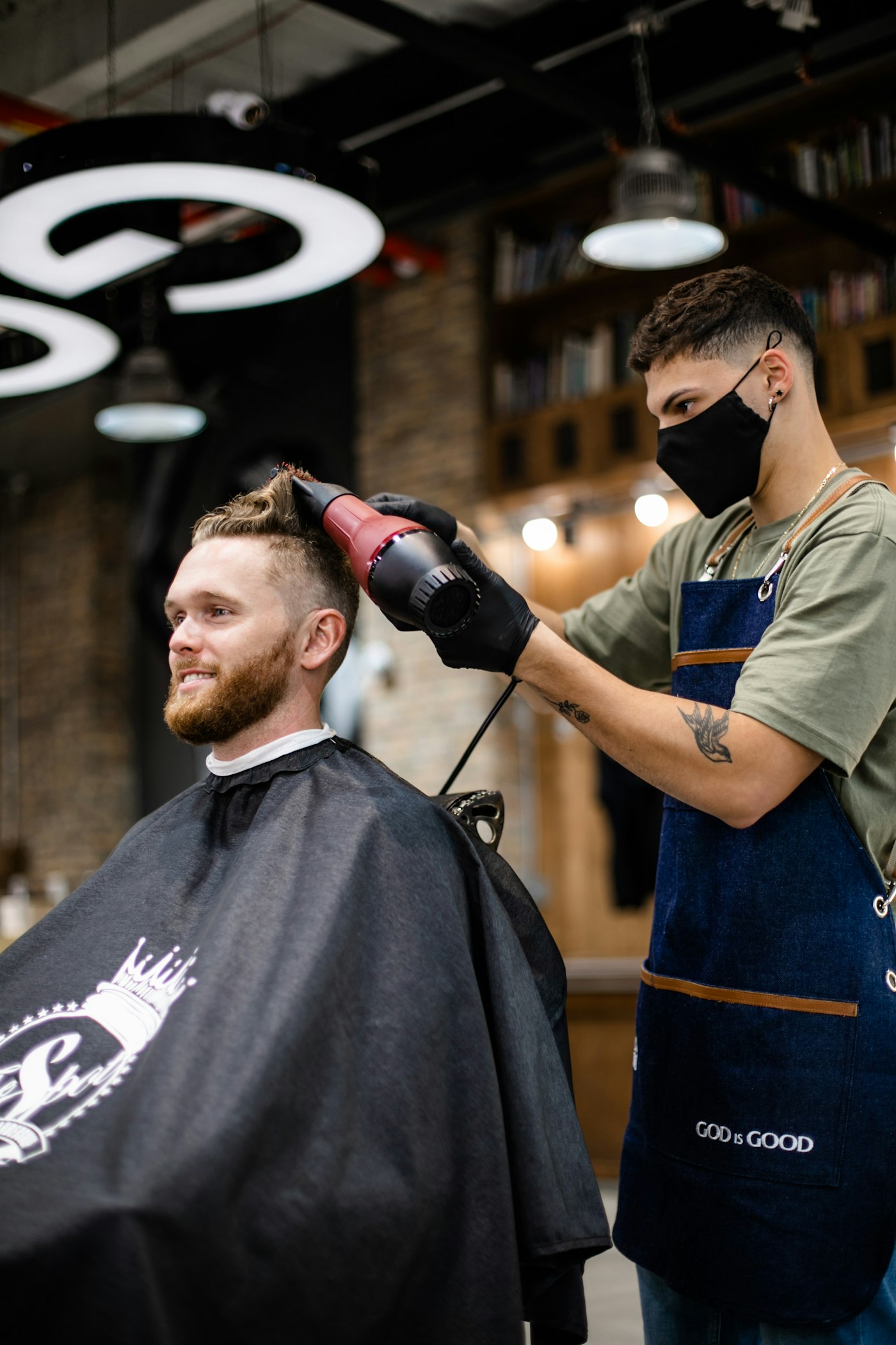 Illustrative photograph of a barber blow-drying a man’s short haircut; not Fade Check staff, premises or work